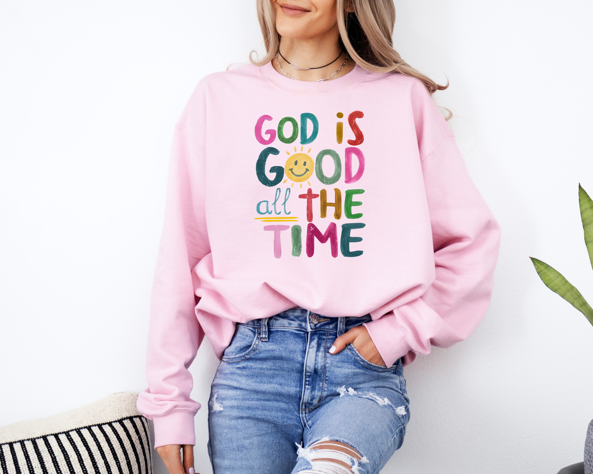 Light pink God is good shirt with a rainbow colored painted design that says "god is good all the time."