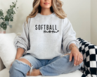 simple softball mom sweatshirt design with heart attached to the word mom in cursive.  Color is ash design is black