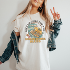 womens summer graphic tee in ivory.  The design says ain't no cure for the summertime blues in a vintage themed design.  The design is a big wave with a skeleton surfing with a guitar and some palm trees and flowers.