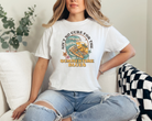 womens summer graphic tee in white  The design says ain't no cure for the summertime blues in a vintage themed design.  The design is a big wave with a skeleton surfing with a guitar and some palm trees and flowers.