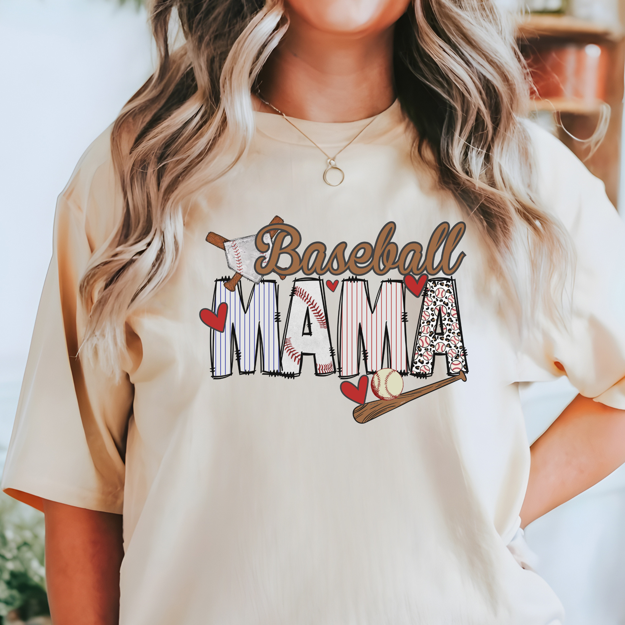 baseball mama tshirt in ivory.  The design is the word baseball in cursive in light brown and mama letters in different patterns with hearts around it
