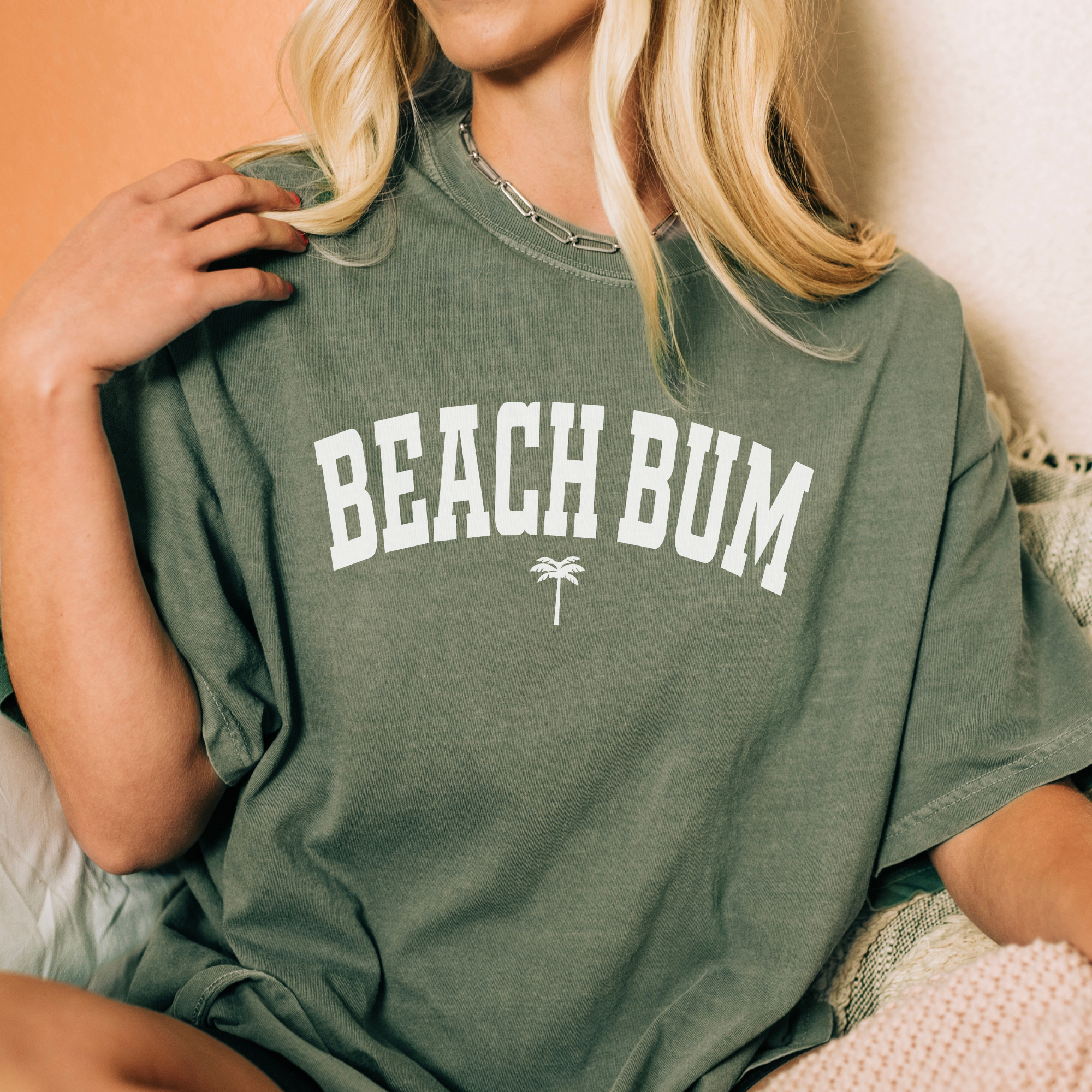beach shirt that says beach bum with a small palm tree. Color is moss green.
