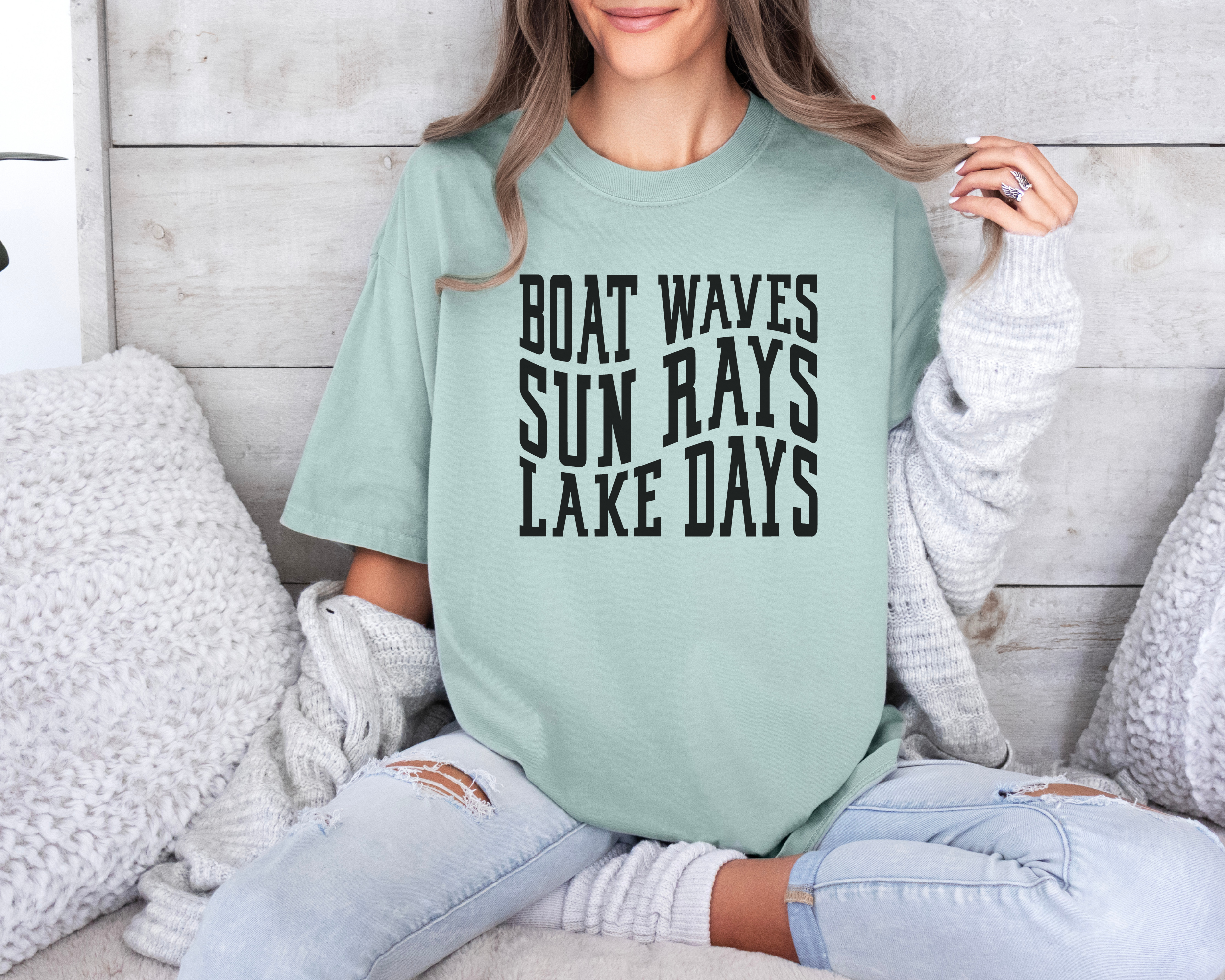 lake shirt that says boat waves sun rays lake days in a wavy text. Shirt color is bay and design in black
