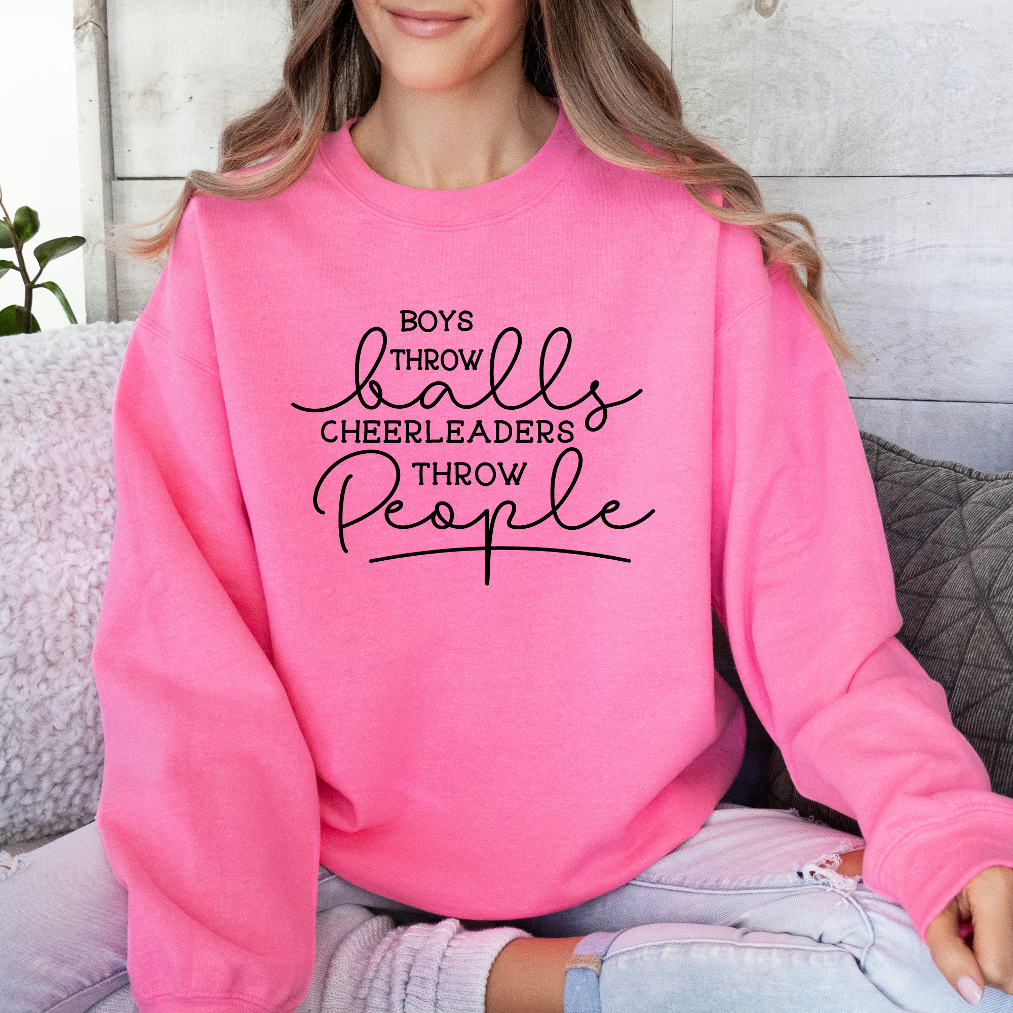 Funny cheer sweatshirt that says boys throw balls cheerleaders throw people in safety pink