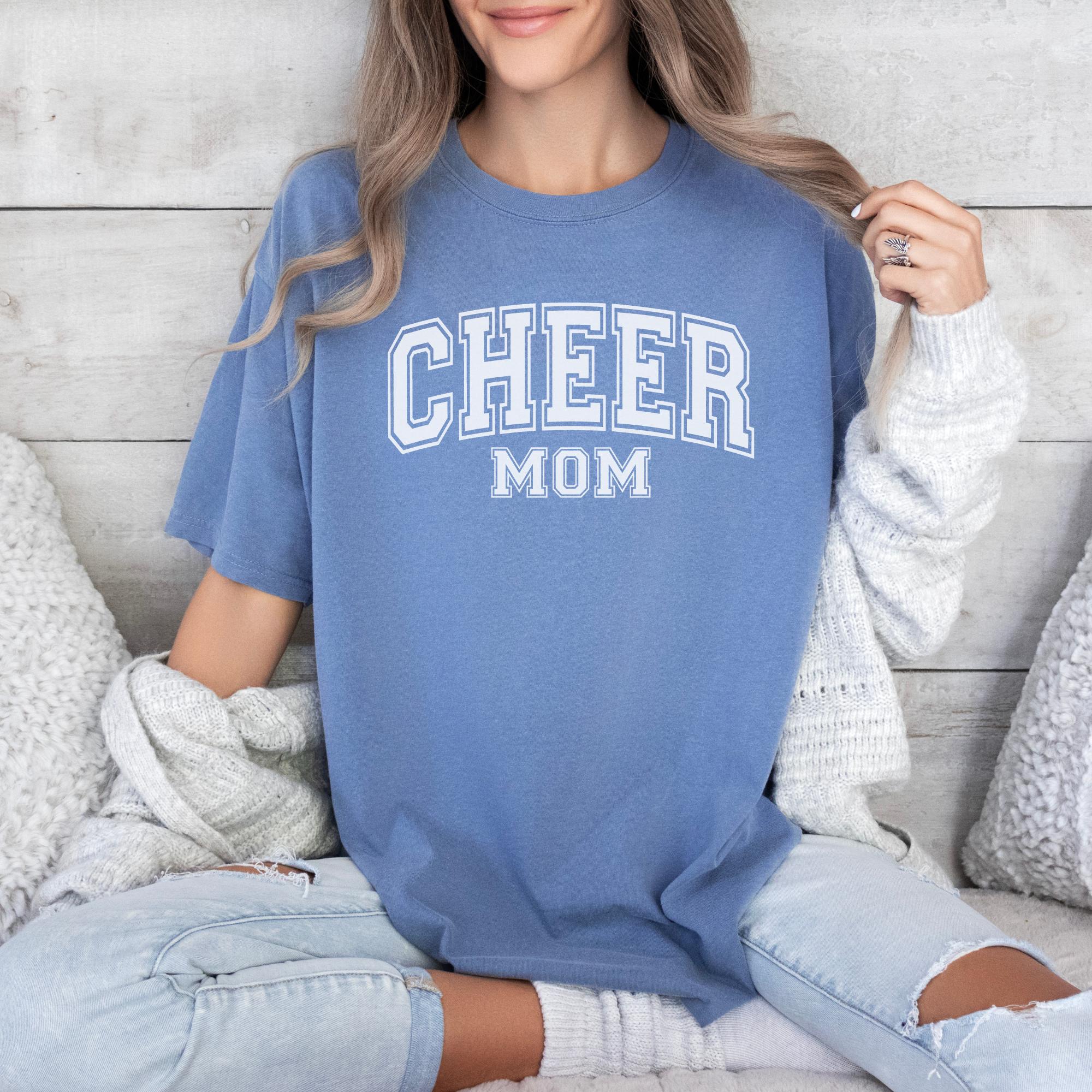 Cheer mom shirt in a college outline text in the color blue with white design.
