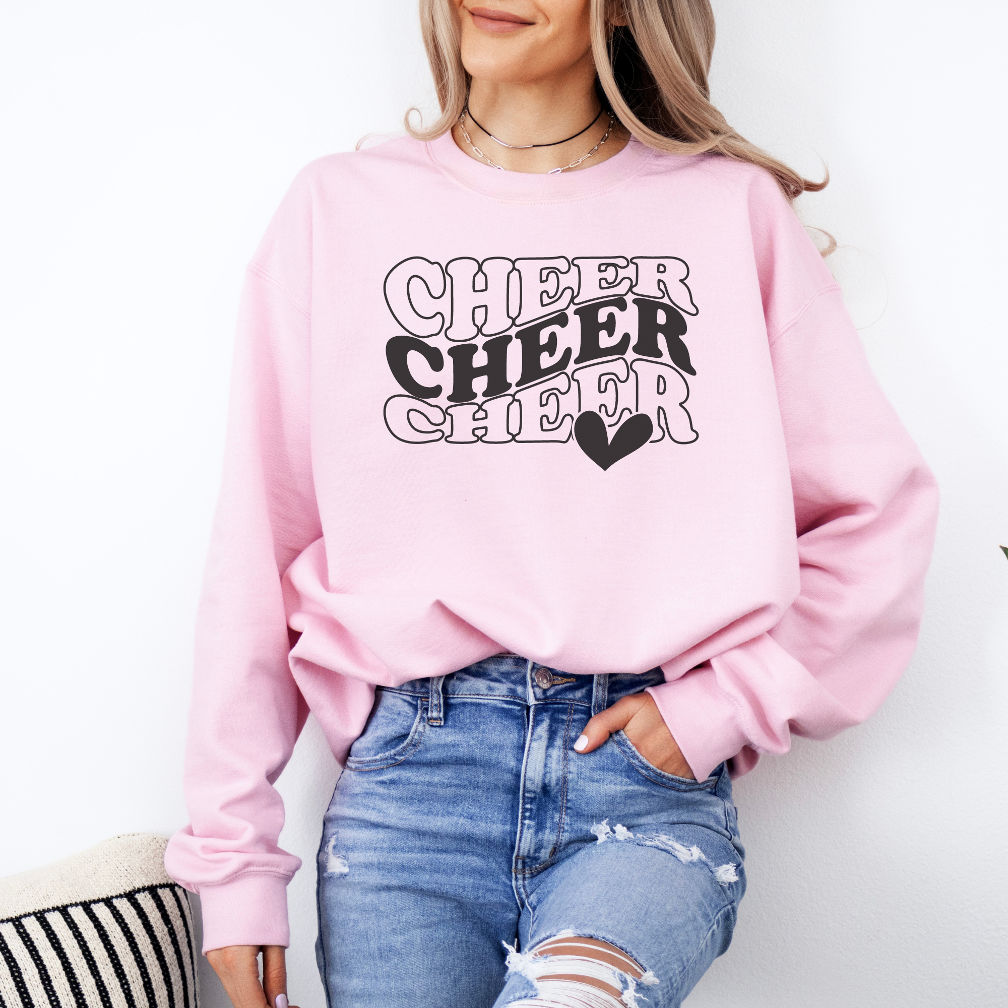 Pink Cheer sweatshirt in in a wavy stacked text with a heart.
