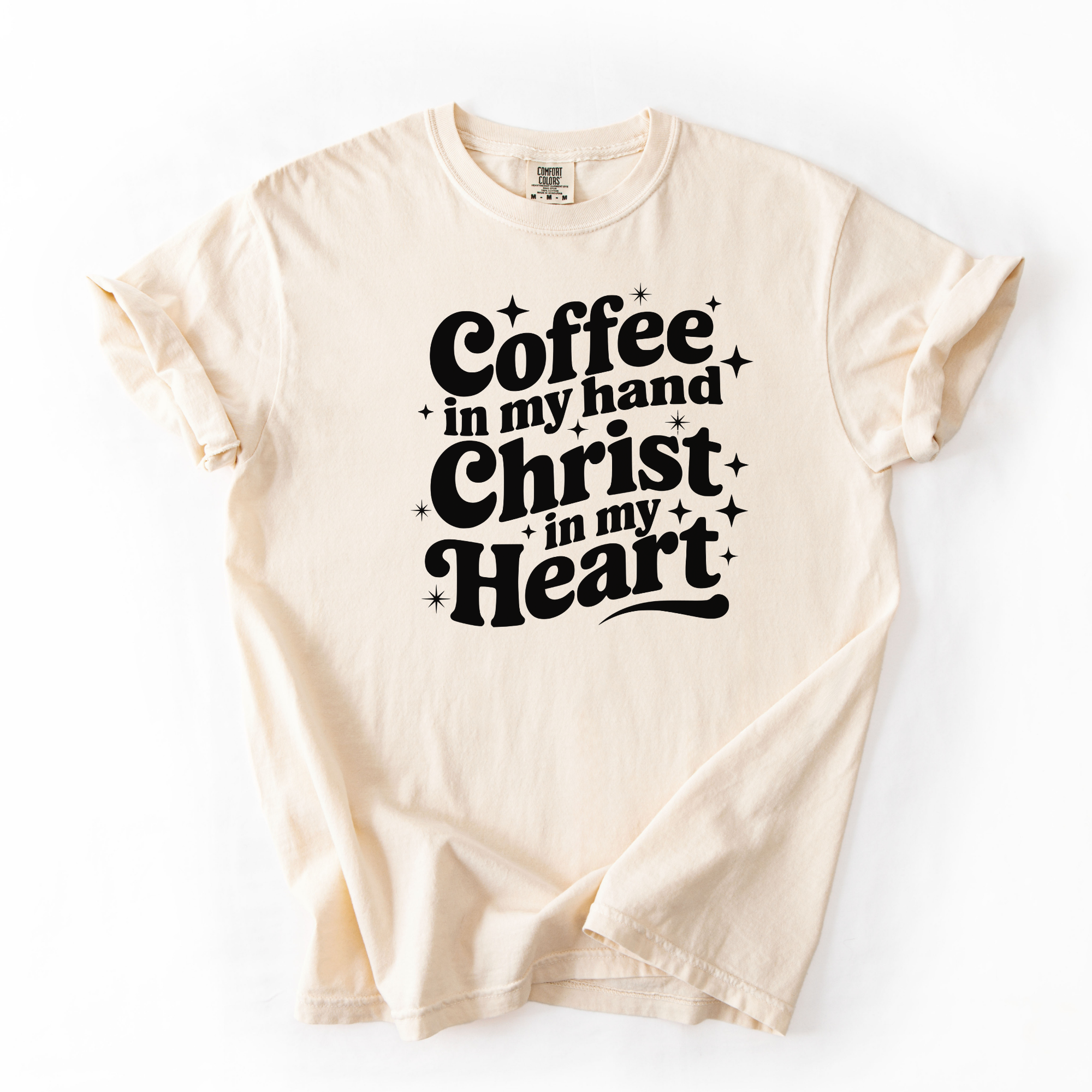 Ivory tee with black text that says "coffee in my hand christ in my heart." This shirt is meant for women who love Jesus and coffee.