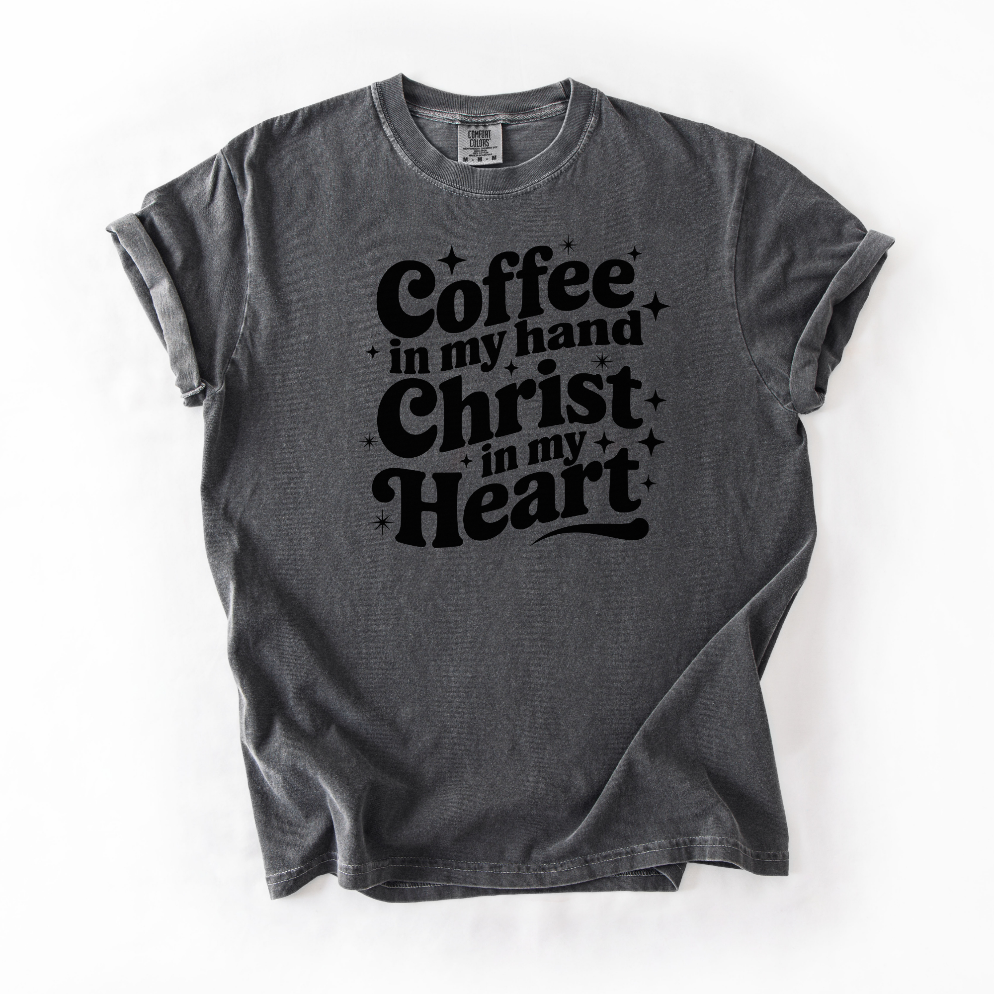 Pepper tee with black text that says "coffee in my hand christ in my heart." This shirt is meant for women who love Jesus and coffee.