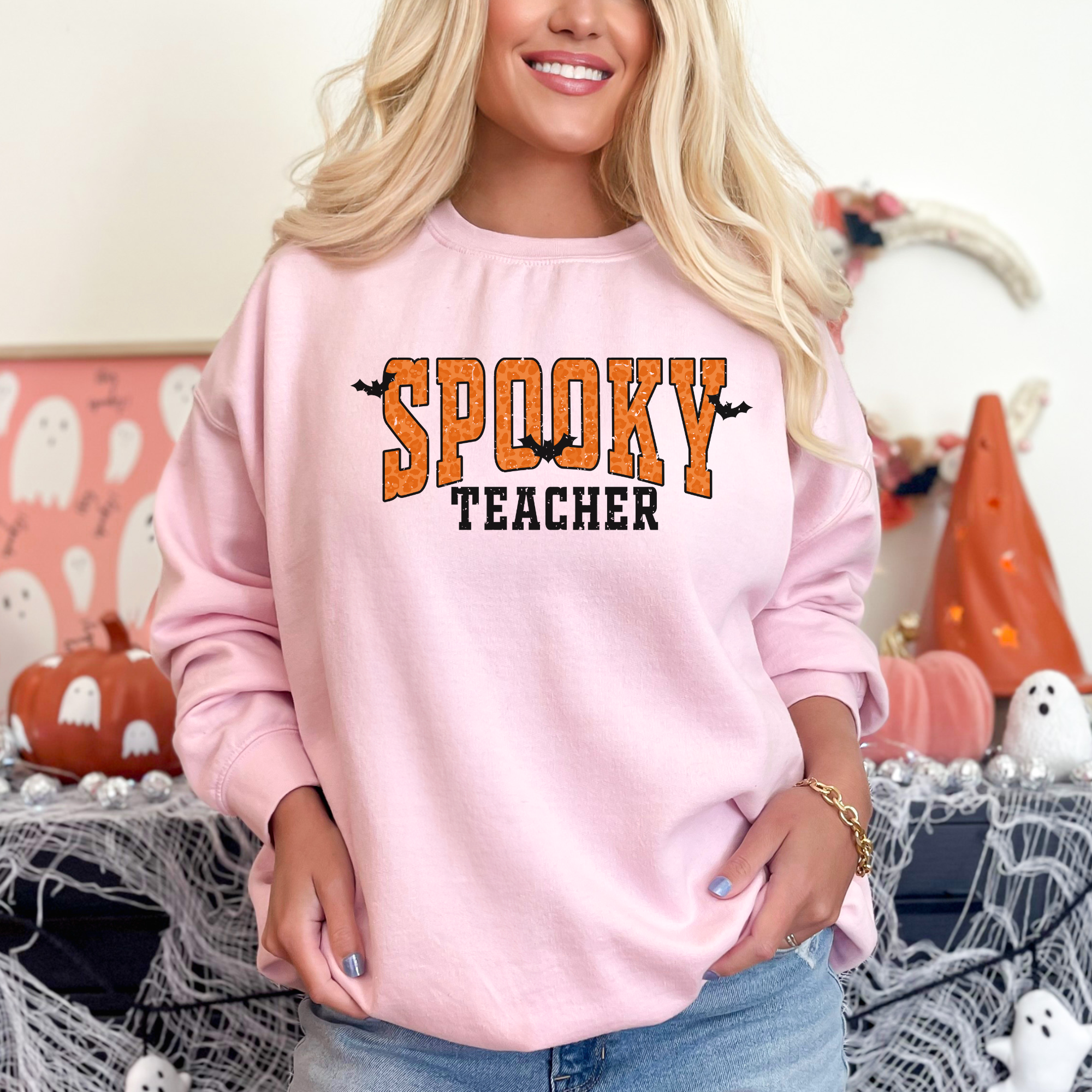 Orange Spooky teacher design on a crewneck sweatshirt in the color pink