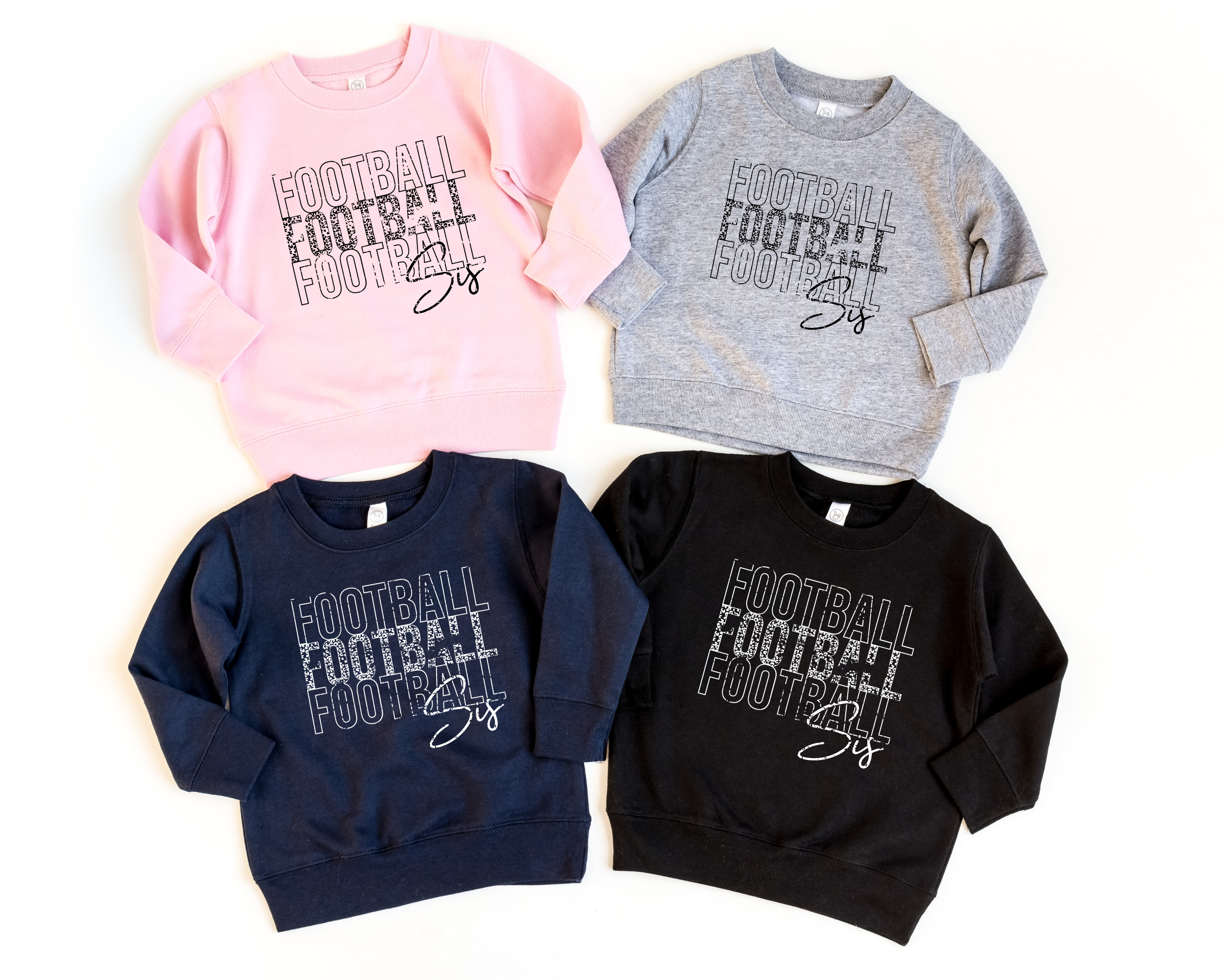 Football sis stacked sweatshirts in light pink, gray, navy, and black.  The navy and black options have a white design.